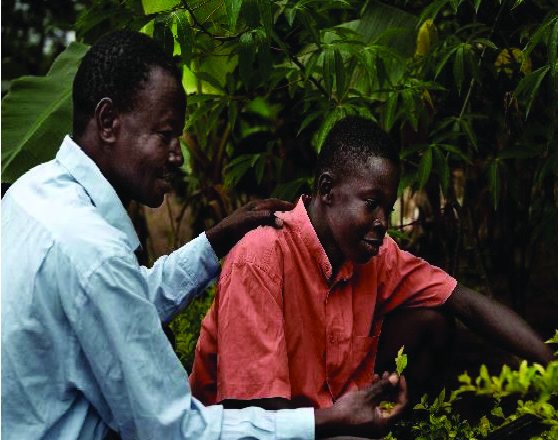 An older man mentoring a young boy in a garden setting